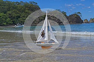 Toy orange ship sails to meet adventures on a beautiful beach