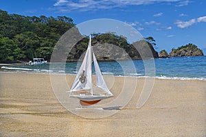 Toy orange ship sails to meet adventures on a beautiful beach