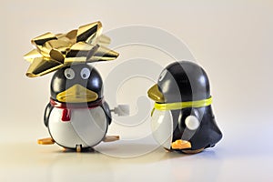 Toy Penguin Looking At Other with Xmas Bow on Head