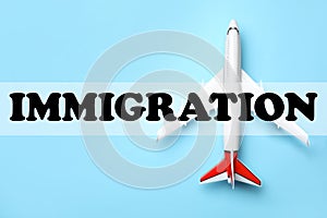 Toy plane on blue background, top view. Immigration concept