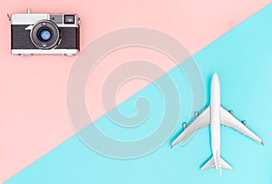 Toy plane and camera on pink and blue background