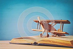 Toy plane and the open book on wooden table