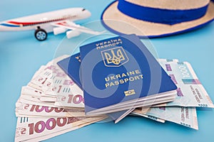 Toy plane with Ukrainian passports and hryvnia on blue