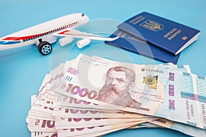 Toy plane with Ukrainian passports and hryvnia on blue