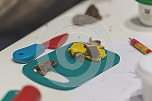 Toy plasticine with plastic tools on a white table