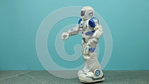 Toy robot dancing on blue background.