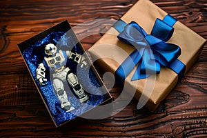 toy robot in a gift box with blue bow on wooden table