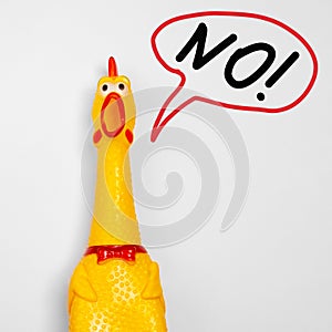 Toy rubber shriek yellow chicken isolated on white background with thought bubble and screams the word NO. copy space. not