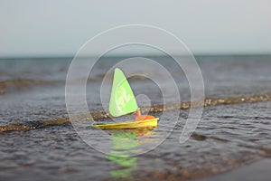 Toy sailboat sailing on the water. Children\'s toy. Summer, daytime. Selective Focus