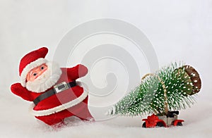 Toy Santa Claus and car carrying Christmas tree in snowy landscape. Space for text.