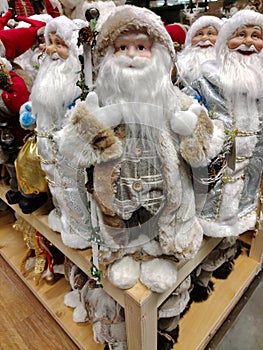 Toy Santa Clauses stand on a store shelf for sale
