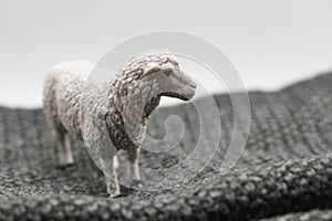 toy sheep miniature on a woolen sweater