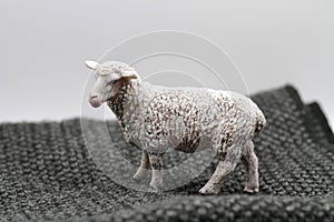 toy sheep miniature on a woolen sweater