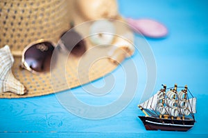 Toy ship, blurred hat, sunglasses and shells on back