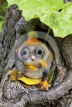 A toy small owl made of wool with beady eyes and a plastic beak in light colors