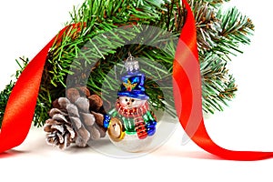 Toy snowman under a branch of an artificial Christmas tree with the cone