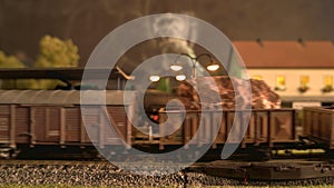 Toy steam locomotive arriving at train station.