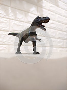 Toy T-Rex standing at the soft yellow bed