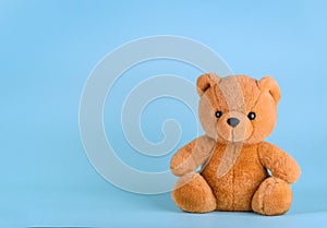 Toy teddy bear on blue background with copy space