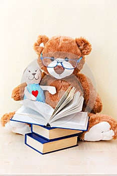 Toy teddy bear reading an interesting book, showing that even read toys. the concept of baby learning