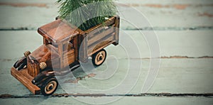 Toy tempo carrying christmas fir on wooden plank
