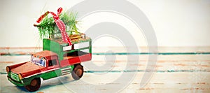 Toy tempo carrying christmas fir on wooden plank