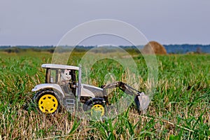 Toy tractor with toy tractor driver cow