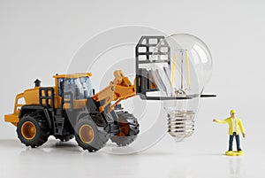 Toy tractor and worker transport and prepare an LED lamp for installation. Transport, loading, unloading and installation services