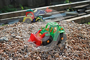 Toy tractors on a pile of rubble, kids game