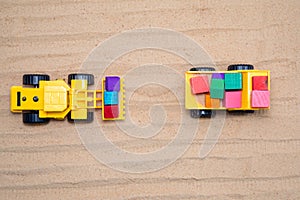 Toy tractors work in the sand Wooden toy car in cartoon style on yellow background. Colorful and Transportation