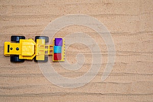 Toy tractors work in the sand Wooden toy car in cartoon style on yellow background. Colorful and Transportation