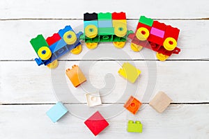 A toy train of cubes of lego and wooden blocks on a wooden background. Educational toys