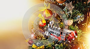 A toy train delivers Santa Claus gifts on Christmas Eve. A steam locomotive rides on rails on a Christmas tree.