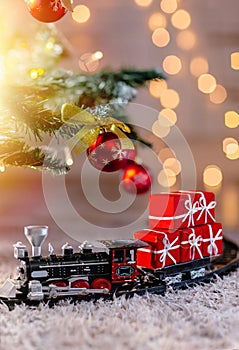 A toy train delivers Santa Claus gifts on Christmas Eve. Transportation of goods by rail on holidays.