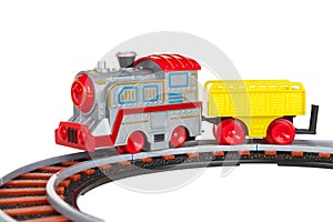 Toy train with freight car trolley on railway tracks, isolated on white background, children`s railway with steam locomotives, ba