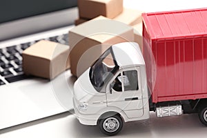 Toy truck near laptop. Logistics and wholesale concept