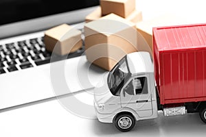 Toy truck near laptop. Logistics and wholesale concept