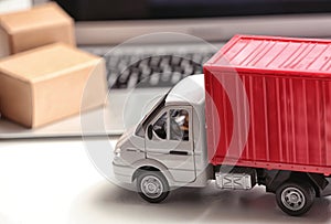 Toy truck near laptop. Logistics and wholesale concept