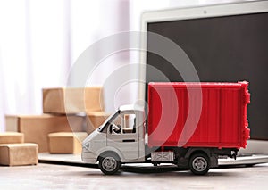 Toy truck near laptop. Logistics and wholesale concept