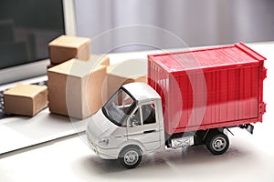 Toy truck near laptop. Logistics and wholesale concept