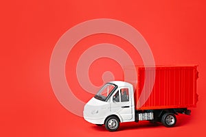 Toy truck on red, space for text. Logistics and wholesale concept