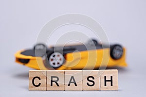Toy upside down car and word Crash, accident concept, auto insurance