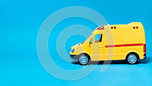 The toy van is yellow with flashing lights on a blue background with a place for copyspace text for the toy store