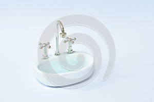 Toy washing sink and water tap for used in bathroom full with soap bubble on white background