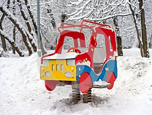 Toy wooden car in snow on playground