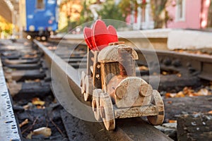 Toy wooden children`s steam locomotive rides in the park