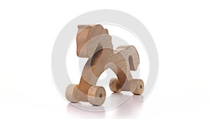 toy wooden horse on wheels is spinning on white background. Wooden craft on turntable rotation, children's toy detailed