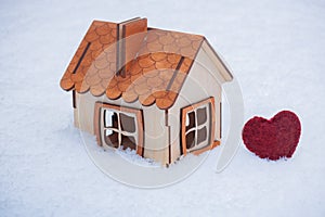 Toy wooden house in snow in cold winter, gas and electricity price, heating bills