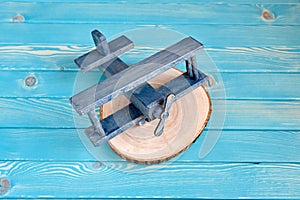 The toy wooden plane on a tree cut on a blue wooden background