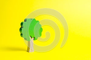 Toy wooden tree on an yellow background. Minimalism and the concept of environmental conservation. lungs of the planet. Family